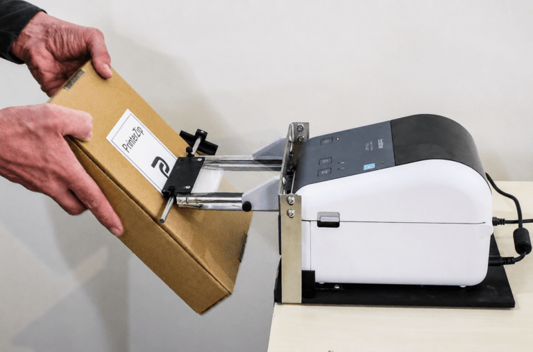 image of label being applied to a box with the PrinterZip Z10 label printer applicator